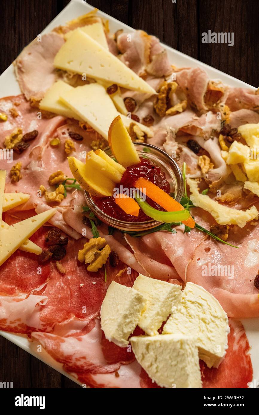 An Italian cheese and sausage platter on a rustic wooden table Stock Photo