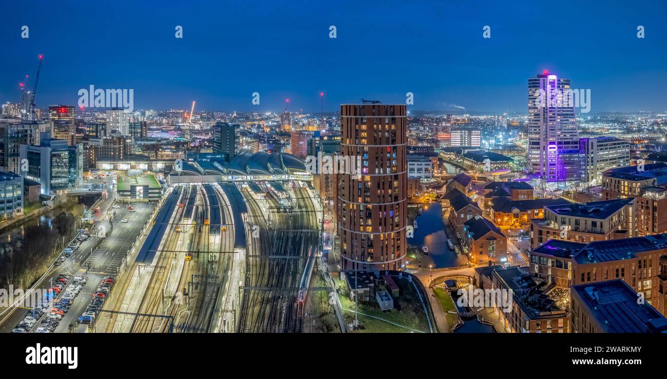 Leeds Train Station aerial view of the railway station in Leeds city centre at night with station platforms and lights at dusk. West Yorkshire Stock Photo