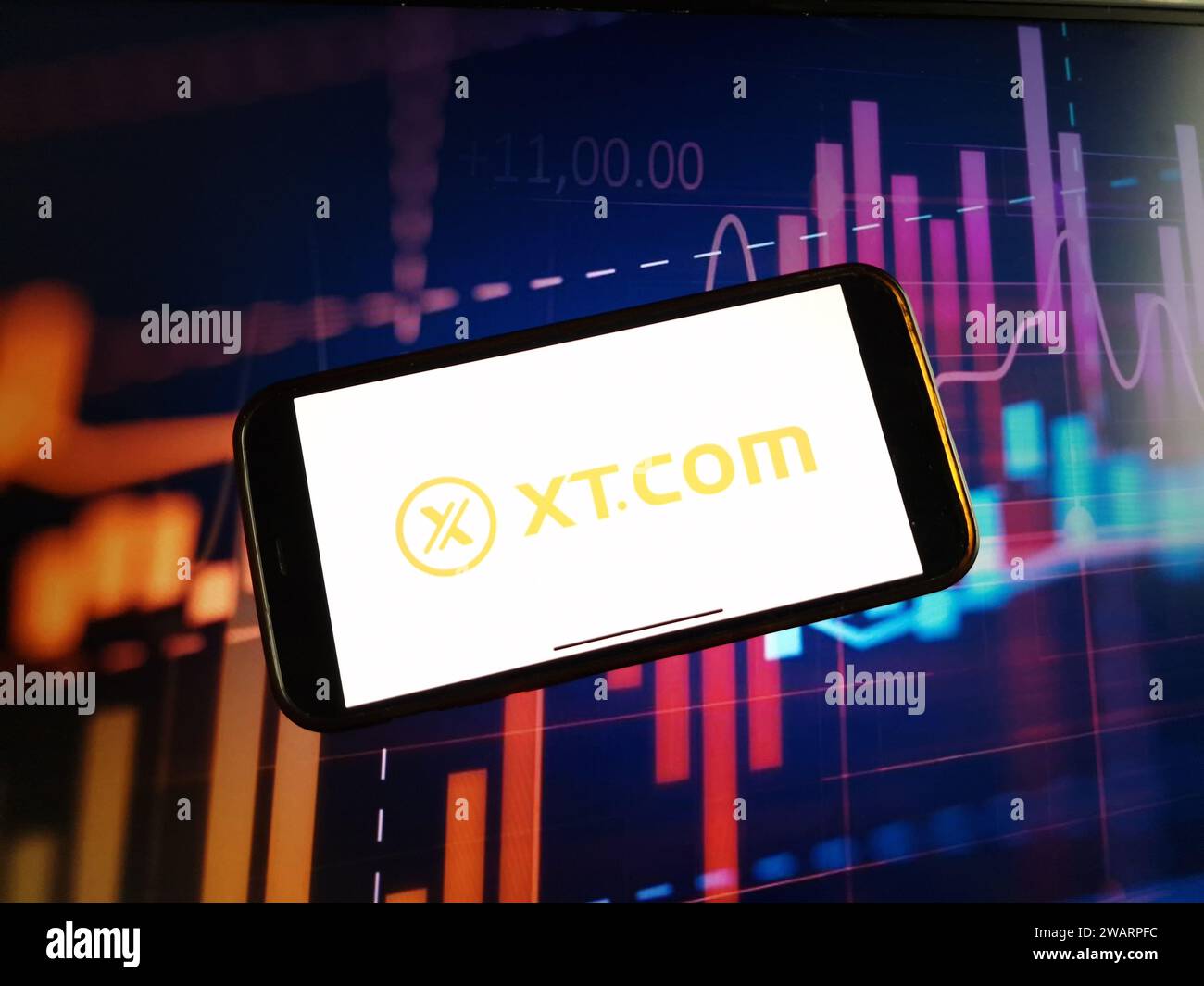 Konskie, Poland - January 05, 2024: XT.COM cryptocurrency exchange logo displayed on smartphone on crypto market data background Stock Photo