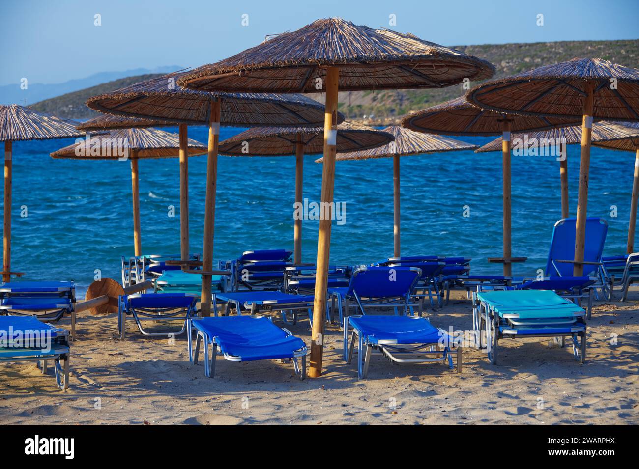Sunbeds and parasols for the tourists on the beaches in Greece Stock Photo
