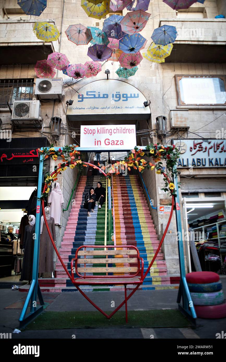 Amman, Amman, Jordan. 6th Jan, 2024. Two women sitting on a staircase in a central street in Amman where there is a heart expressing the current situation in Gaza in relation to the death of innocent children. (Credit Image: © Bruno Gallardo/ZUMA Press Wire) EDITORIAL USAGE ONLY! Not for Commercial USAGE! Stock Photo
