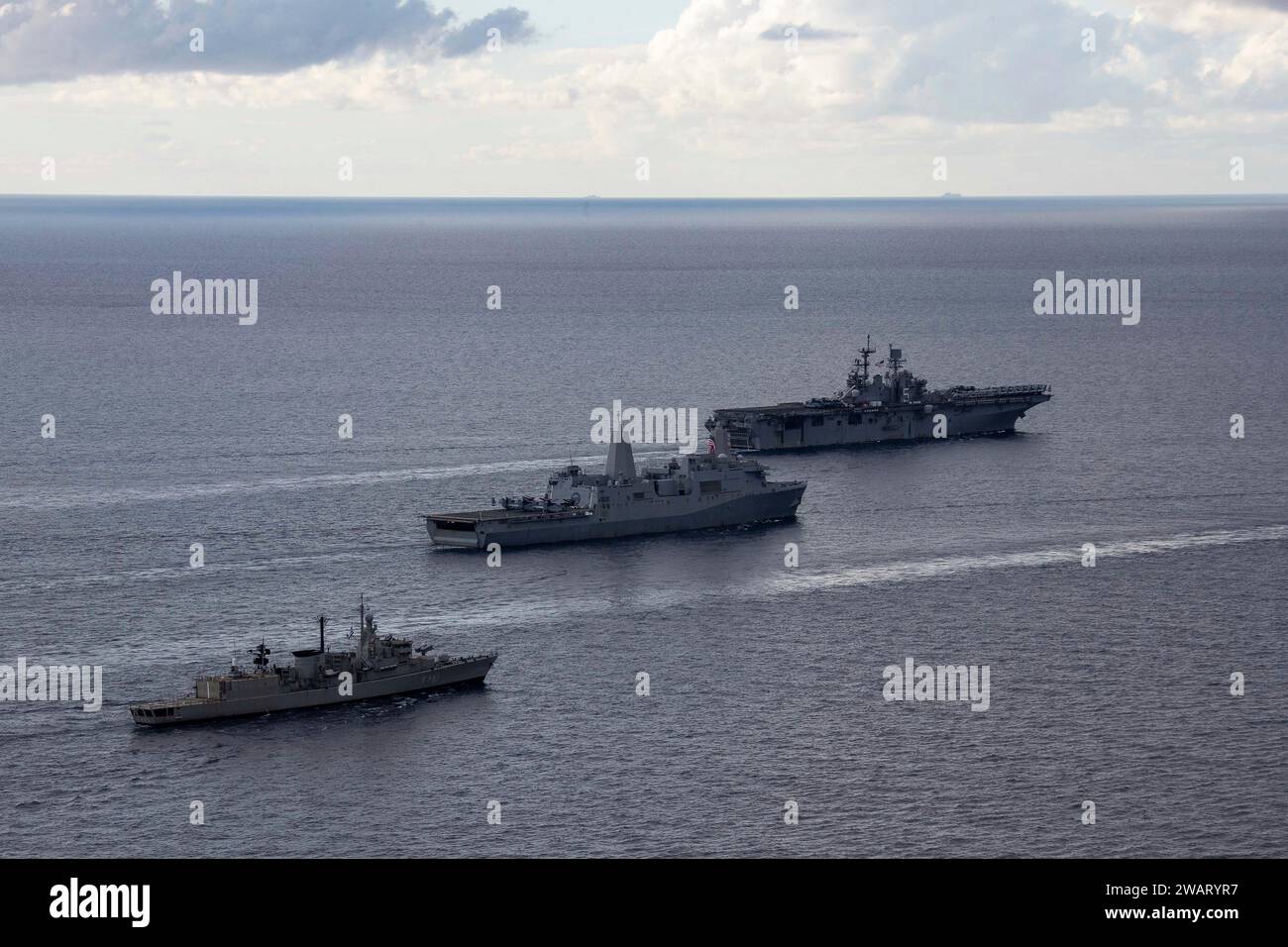 Mediterranean Sea, United States. 31 December, 2023. The U.S. Navy Wasp-class amphibious assault ship USS Bataan, right, followed by the U.S Navy San Antonio Class-class amphibious transport dock USS Mesa Verde and the Hellenic Navy frigate HS Navarinon, right, during a formation of ships from the Bataan Amphibious Ready Group and Hellenic Navy, December 31, 2023 on the Mediterranean  Credit: MC3 Maxwell Orlosky/U.S. Navy Photo/Alamy Live News Stock Photo