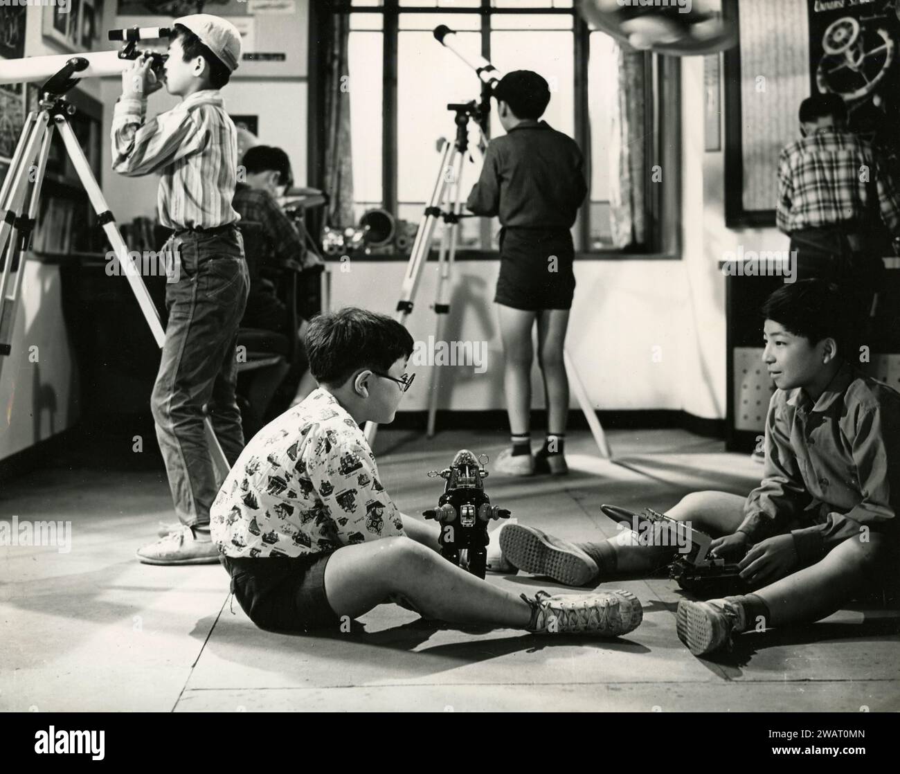 Group of Japanese children playing with telescopes and space age toys