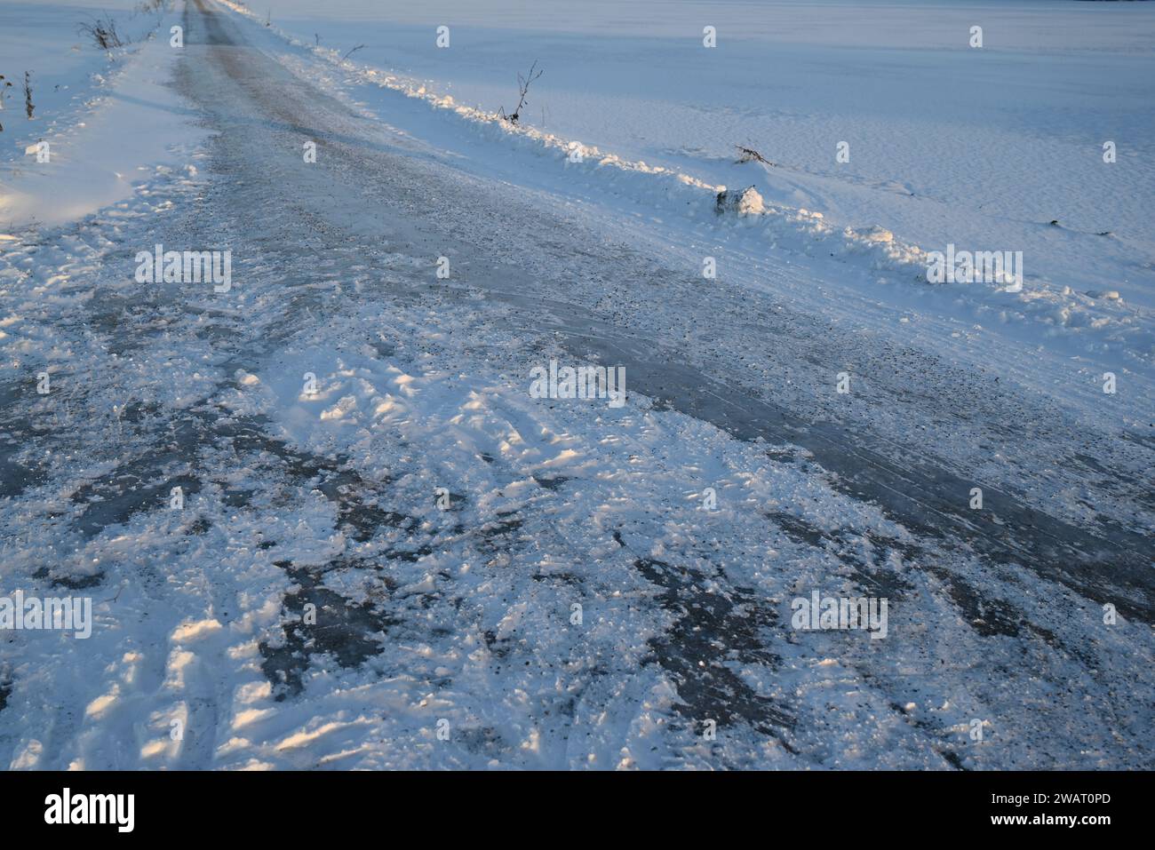 Icy countryside road, with gravel for improved traction. Stock Photo