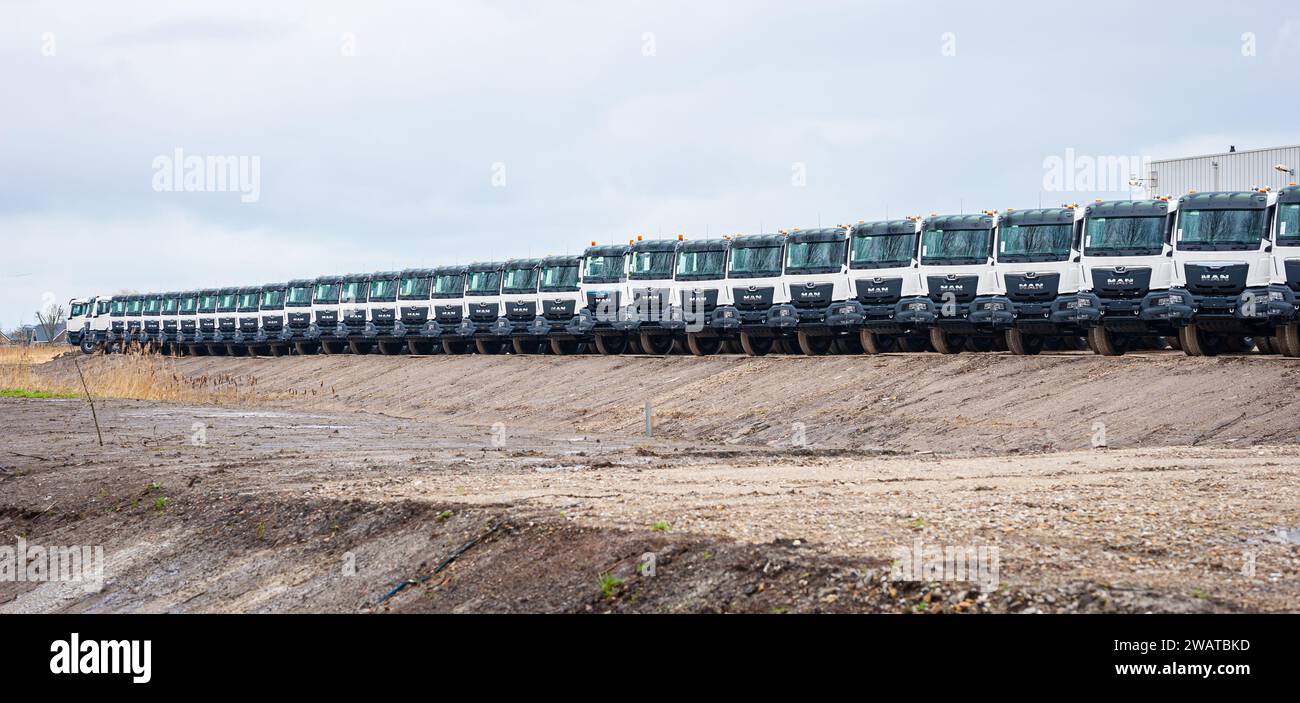 Perspective view of a long row of white trucks. Stock Photo