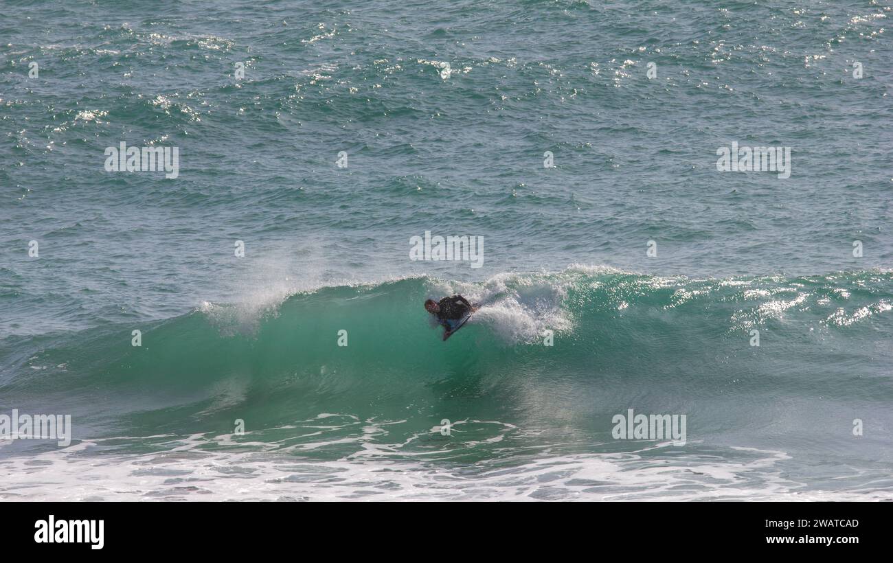 Body boarder catching the breaker at Kynance Cove, Cornwall.  Off the top of the wave Stock Photo