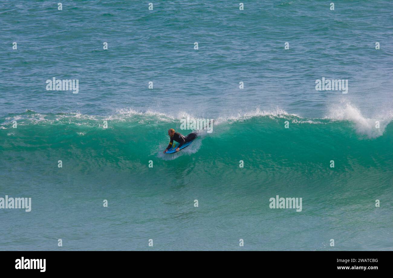 Body boarder catching the breaker at Kynance Cove, Cornwall. Stock Photo