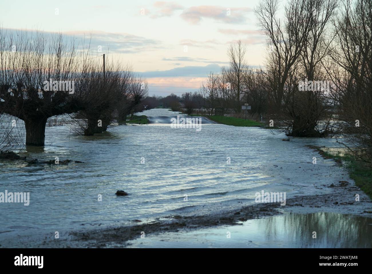Whittlesey, UK. 6th January 2024. Heavy rainfall in the UK causing a road to be closed near the River Nene near Whittlesey flooding. Andrew Steven Graham/Alamy Live News Stock Photo
