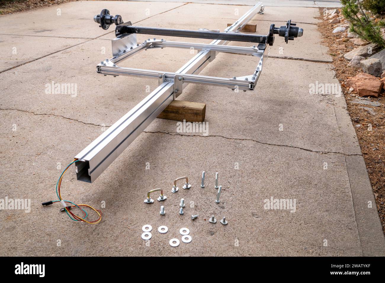 assembling a light and long aluminum kayak or canoe trailer in a driveway Stock Photo