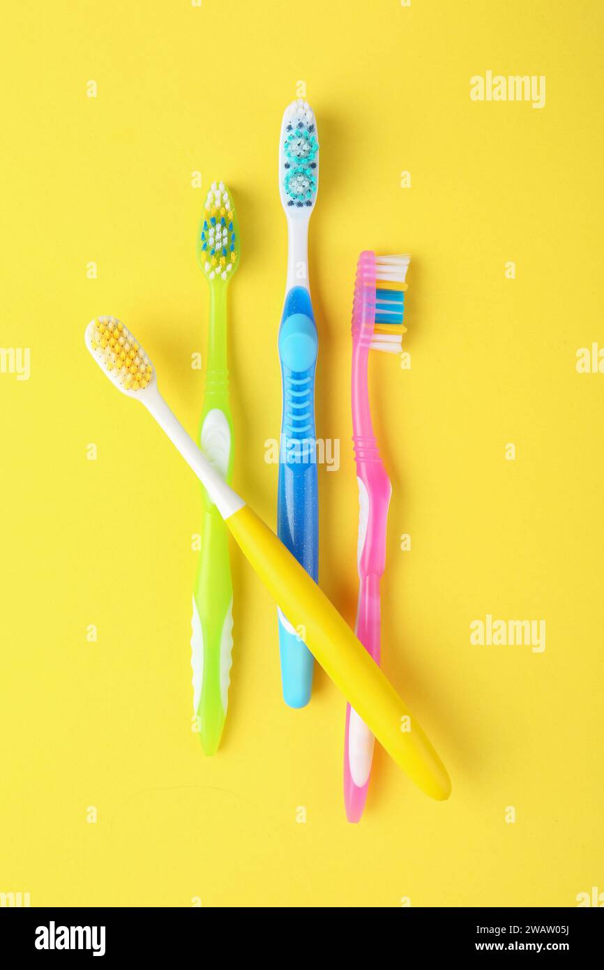 Different toothbrushes on yellow background, flat lay Stock Photo - Alamy