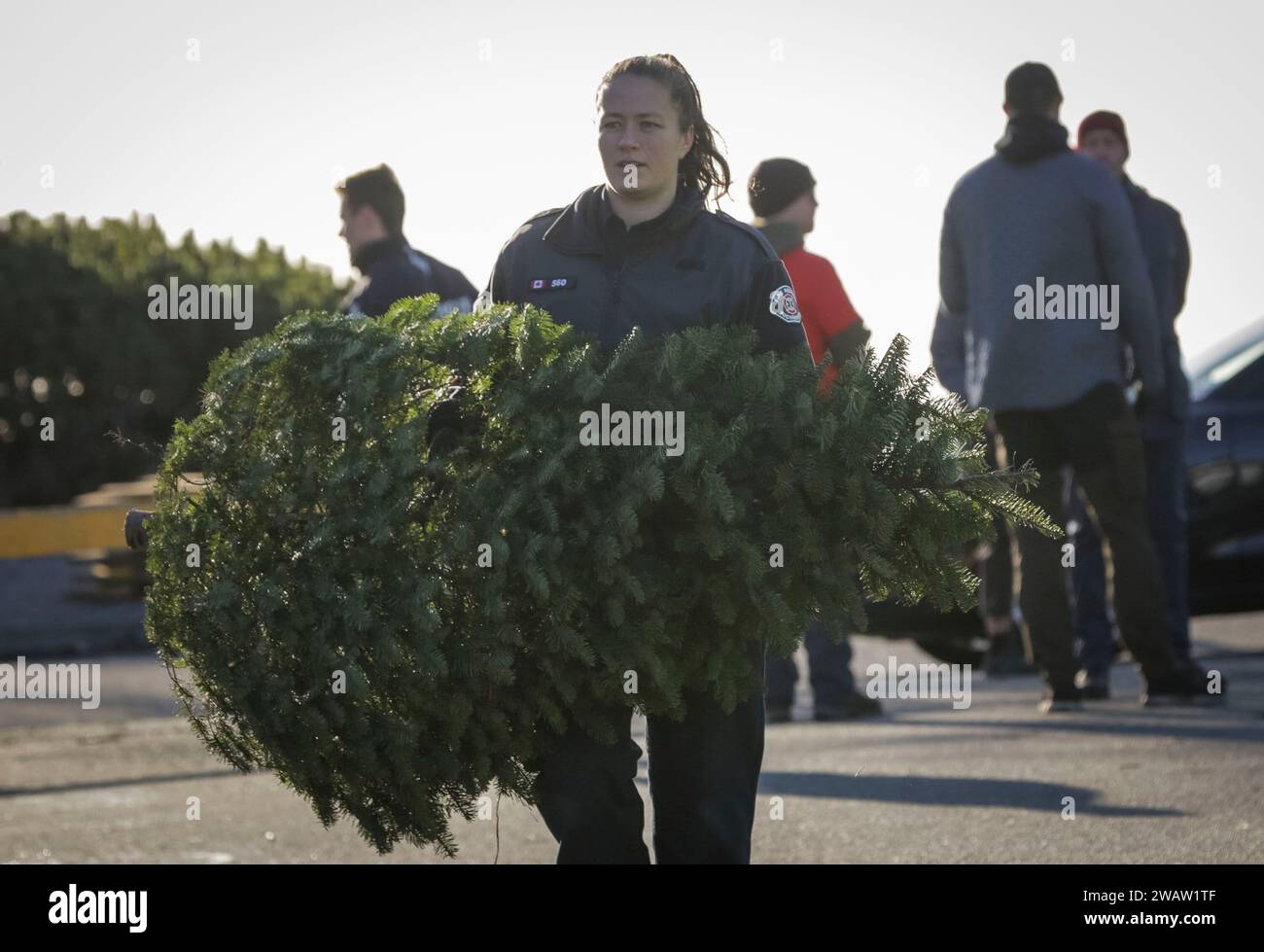 Richmond, Canada. 6th Jan, 2020. A firefighter carries a Christmas tree