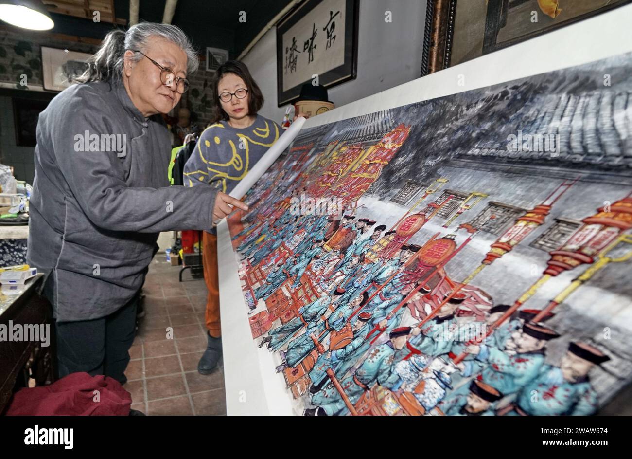 (240107) -- BEIJING, Jan. 7, 2024 (Xinhua) -- Yang Xin shows his 7-meter-long painting at his studio in Beijing, capital of China, Jan. 4, 2024. Yang Xin, 62, is a noted artist of traditional Beijing paintings. His family have been involved in pigment making business since the Qing Dynasty (1644-1911). Fascinated by paintings since his childhood, Yang acquired the craft of pigment making for traditional Beijing paintings from his mother and became the fifth generation inheritor of this art. This craft, which extracts pigment from natural materials such as minerals, soil and plants, was liste Stock Photo