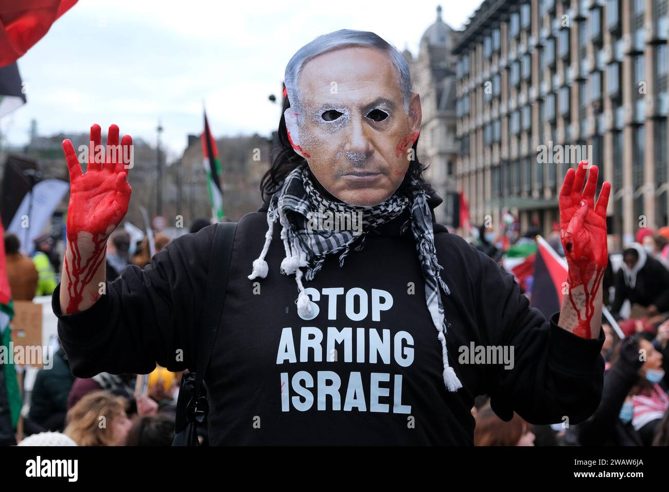 London, UK. 6th January, 2024. A protester with bloodied hands wears a Benjamin Netanyahu face mask. Around a thousand Palestine supporters, including from activist groups Sisters Uncut and BLM, marched through Westminster from St James's Park towards Parliament Square, where the demonstrators were contained by a police cordon, and imposed conditions curtailing further movement. Credit: Eleventh Hour Photography/Alamy Live News Stock Photo