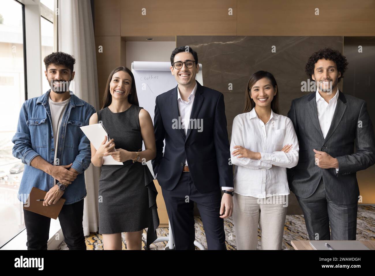 Multiethnic team of cheerful successful young managers smiling at camera Stock Photo
