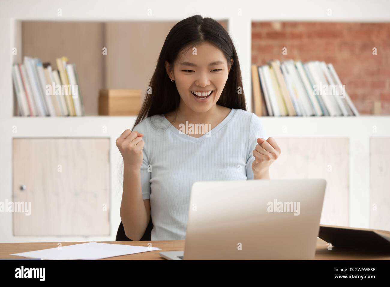 Excited Asian female student feel euphoric getting high grade Stock Photo