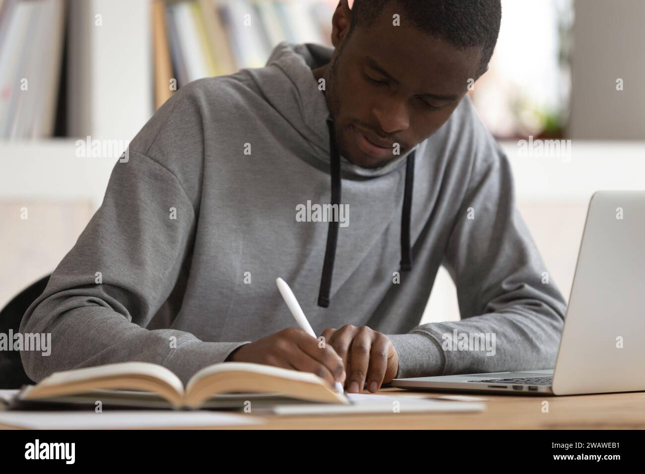 Focused african American guy make notes studying on laptop Stock Photo