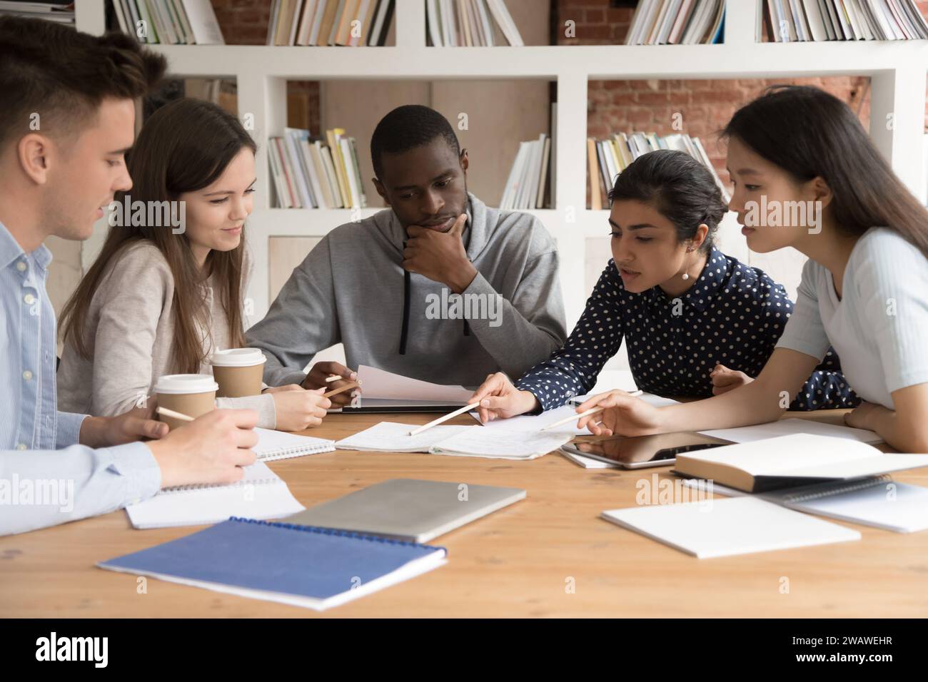 Focused diverse multiracial students work on group project Stock Photo