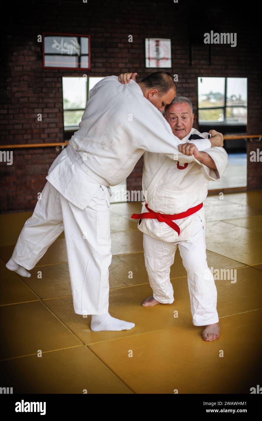 Judo sensei master instructor in traditional gi kimono demonstrate judo throw technique on