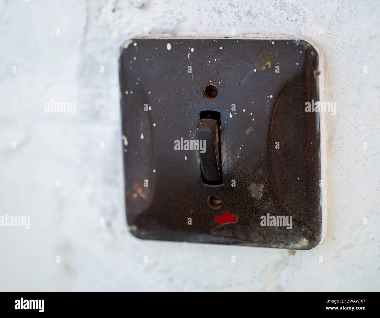 Old black light switch on a white wall. Blurred background Stock Photo