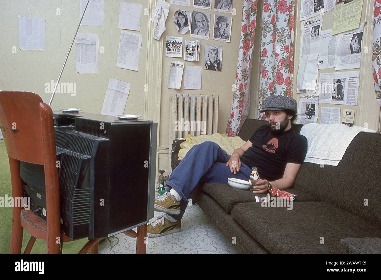 A photo of the late Miguel Piniero, playwright, actor, poet and activist. In his home studio office apartment on the Upper West Side of Manhattan in 1977. There are clippings and reviews on his wall for his play,'Eulogy for a Small Time Thief.' Stock Photo