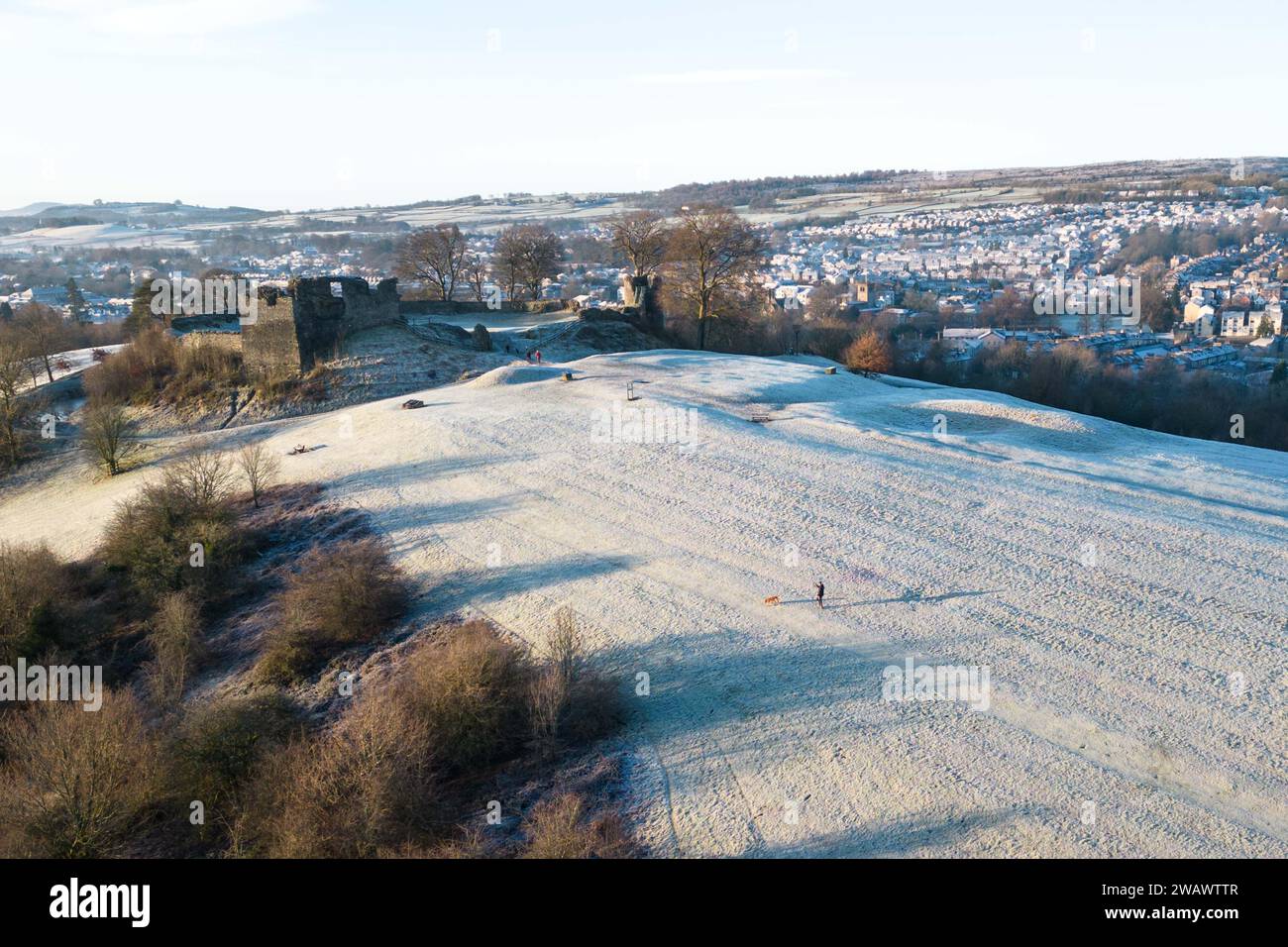 Kendal, Cumbria, January 7th 2024 - A night of mist and sub-zero temperatures brought a beautiful Wintry morning frost to the town of Kendal in Cumbria on Sunday. Kendal Castle which overlooks the Medieval town was surrounded by a white icey layer as dog walkers enjoyed the view. Houses at the foot of the castle are shaped in circles and ovals also caught the frost. Credit: Stop Press Media/Alamy Live News Stock Photo