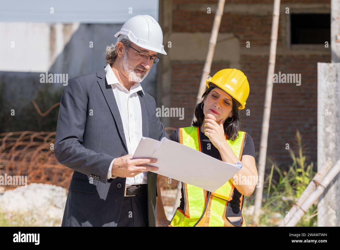 Senior professional architect consulting meeting talking with construction engineer women project manager review planing with floor plan design bluepr Stock Photo