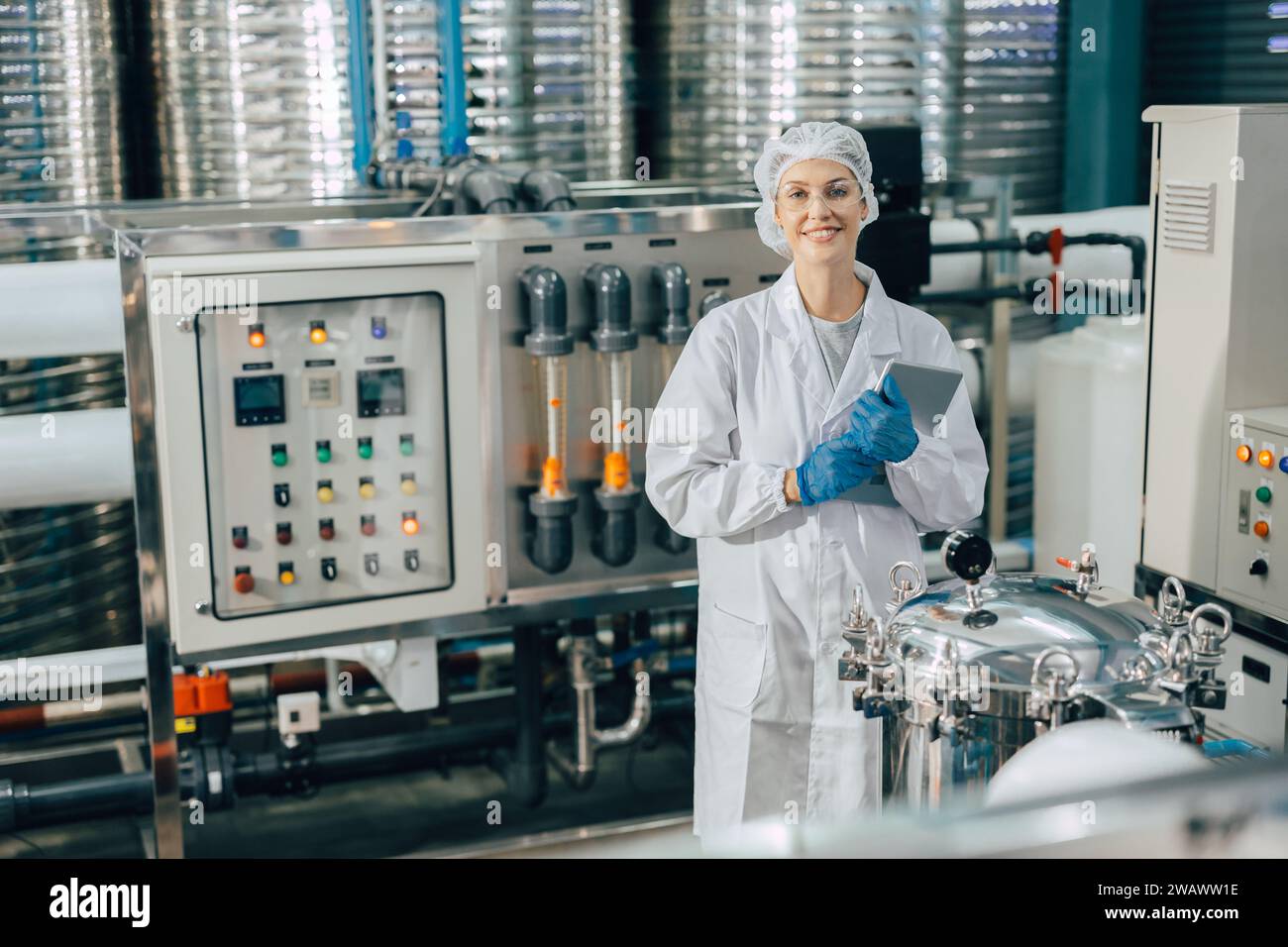 portrait happy women staff worker in drinking water plant work control water quality purification test process. Stock Photo