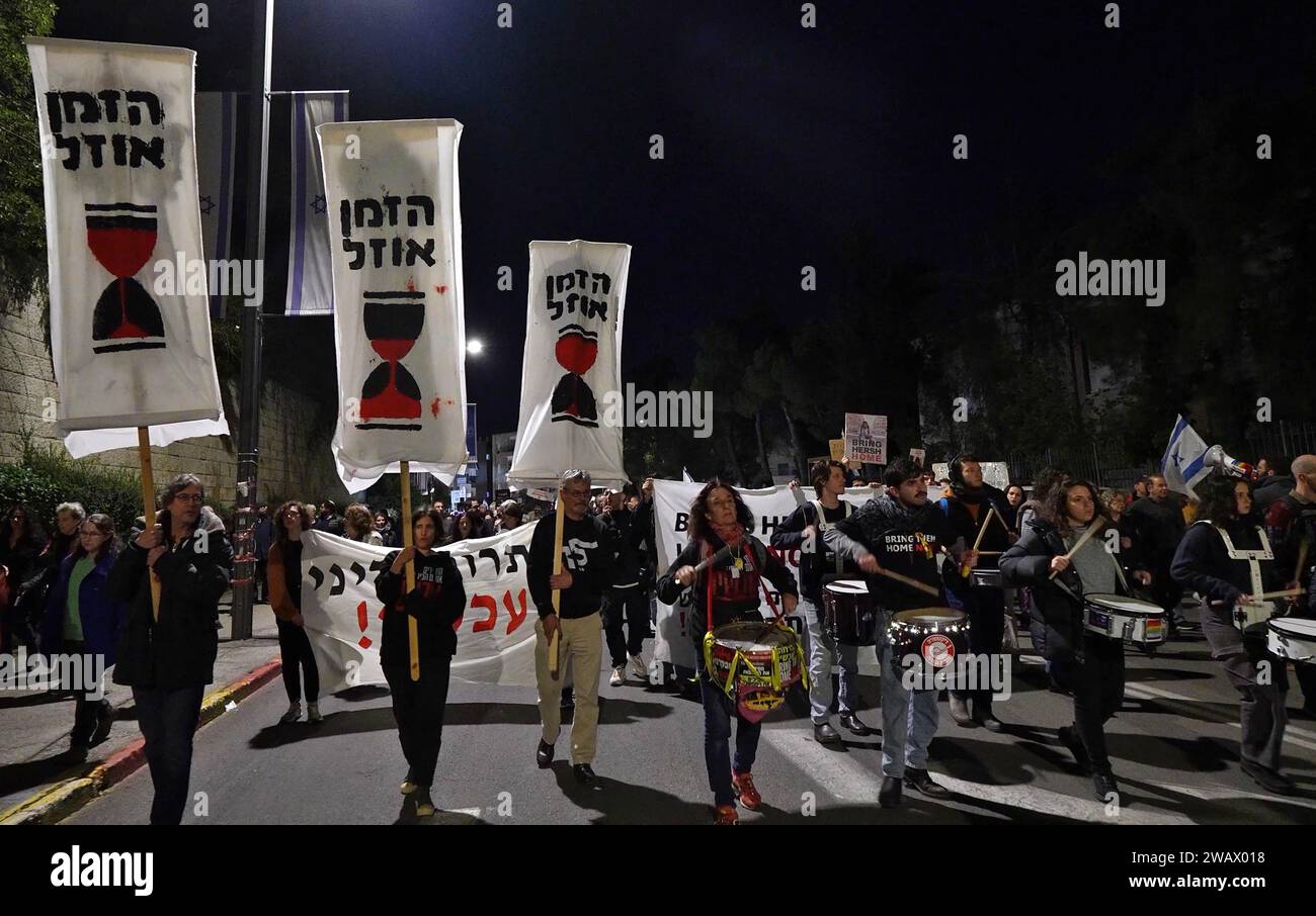 Israelis hold signs that read 'Time is running out' as others beat drums and march during a rally outside the President's Residence calling for a deal to free Israeli hostages held in the Gaza Strip on January 6, 2024 in Jerusalem. More than 100 Israeli hostages captured on Oct. 7 remain held in Gaza by Hamas and other militant groups, according to Israeli authorities. Stock Photo