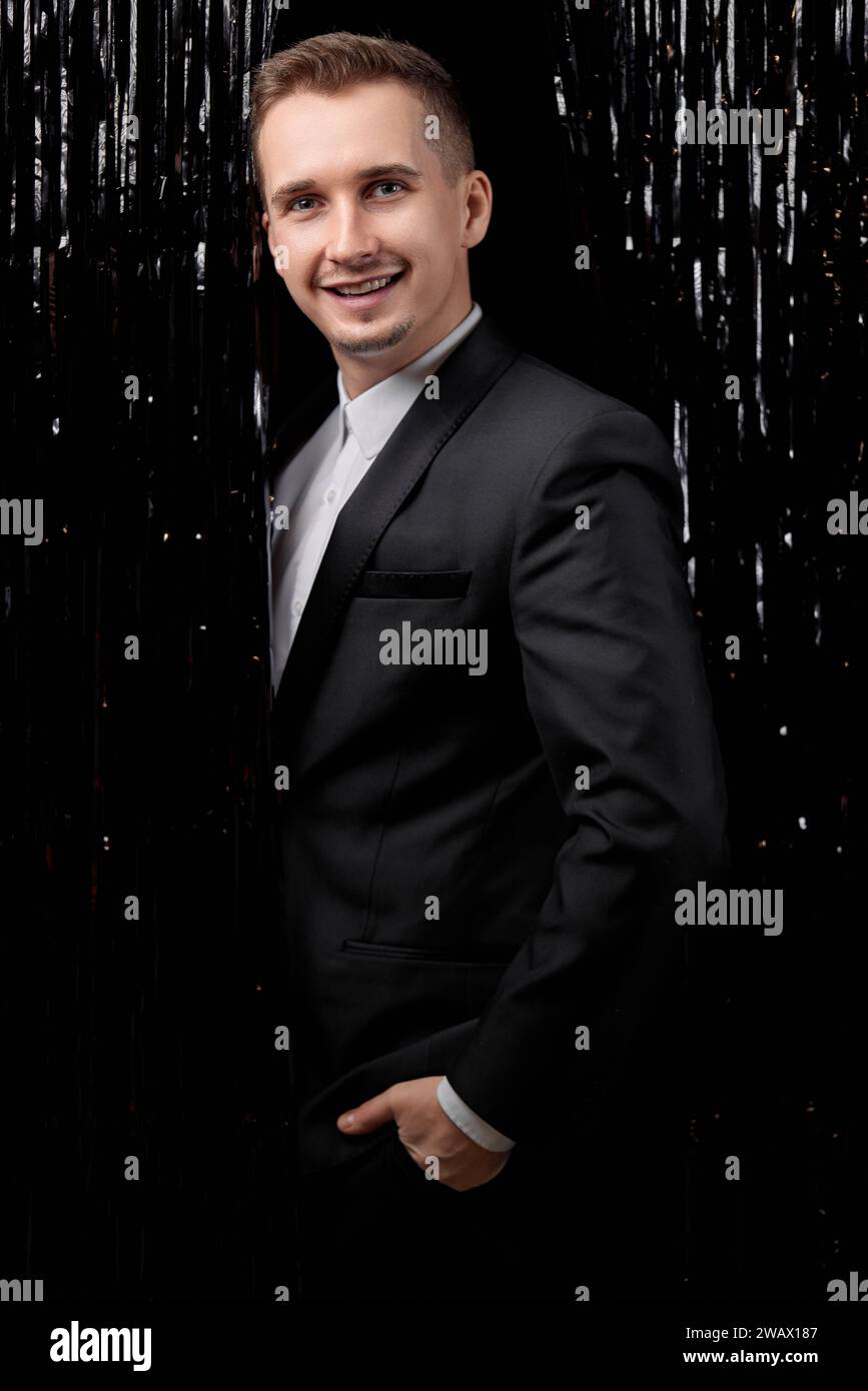 handsome man in black suit smiling on glitter background Stock Photo ...