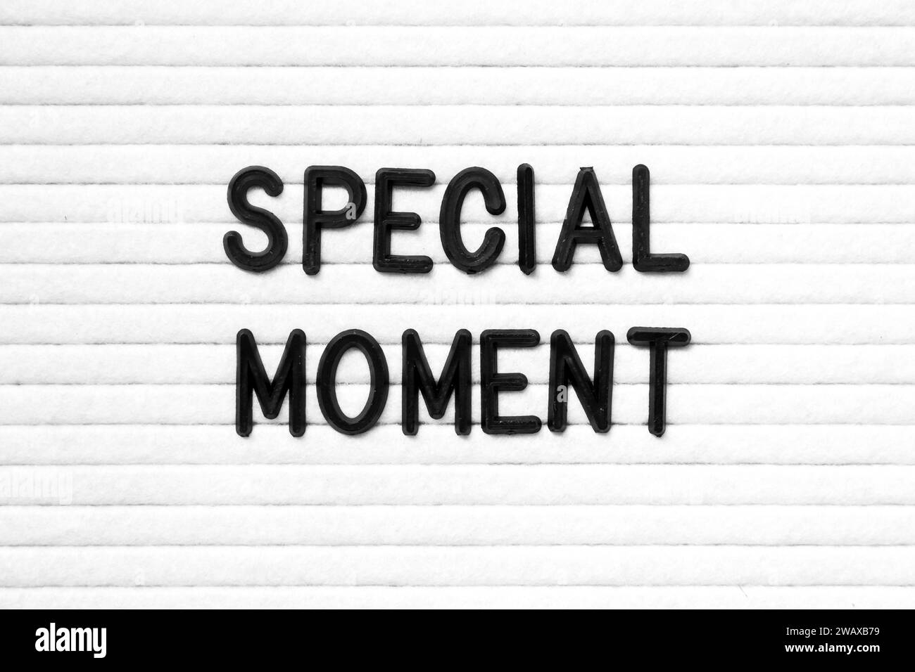 Black color letter in word special moment on white felt board ...