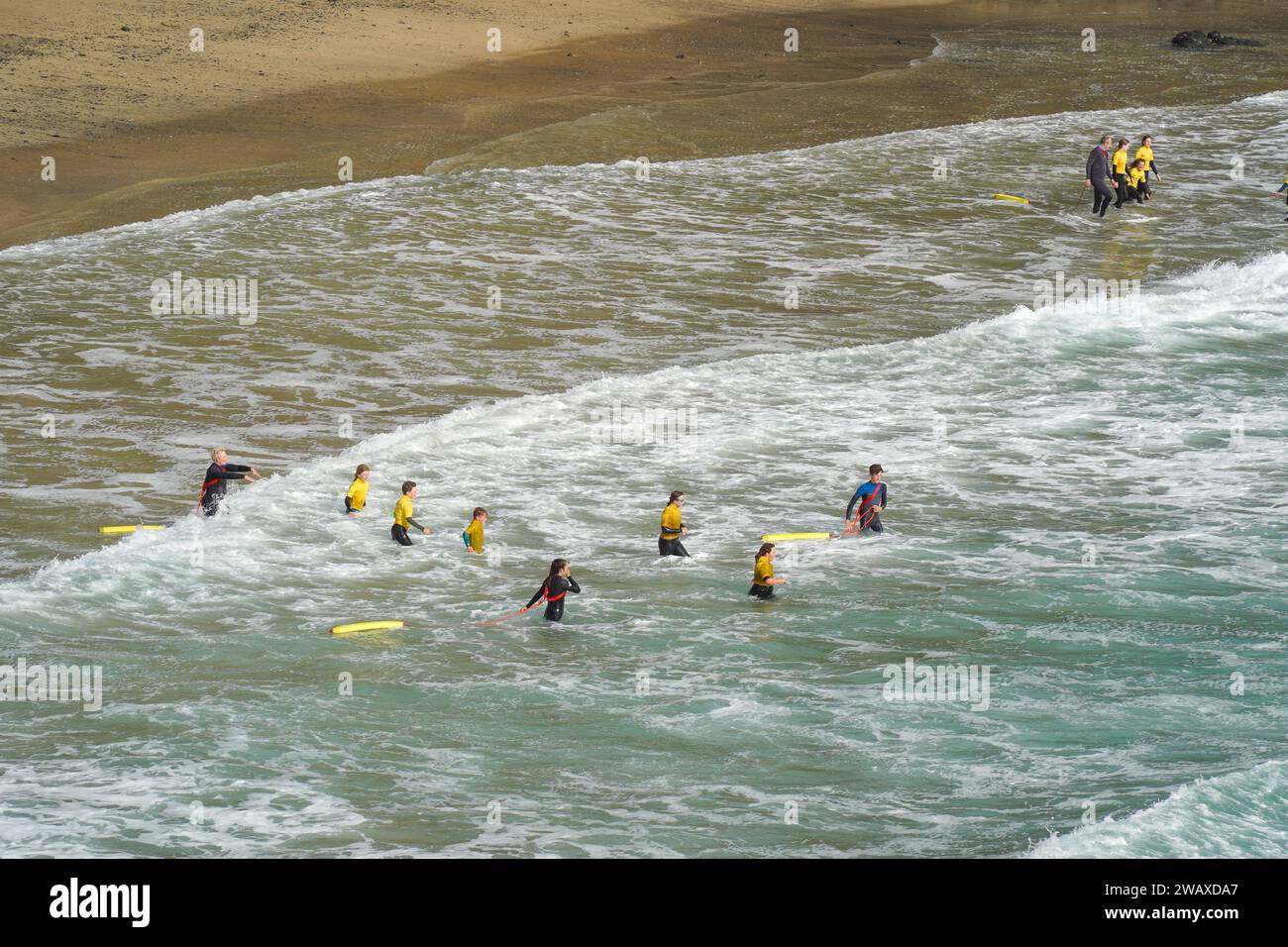 Porthleven, UK 24 June 2022 Young RNLI beach lifeguards training how to swim in rough sea