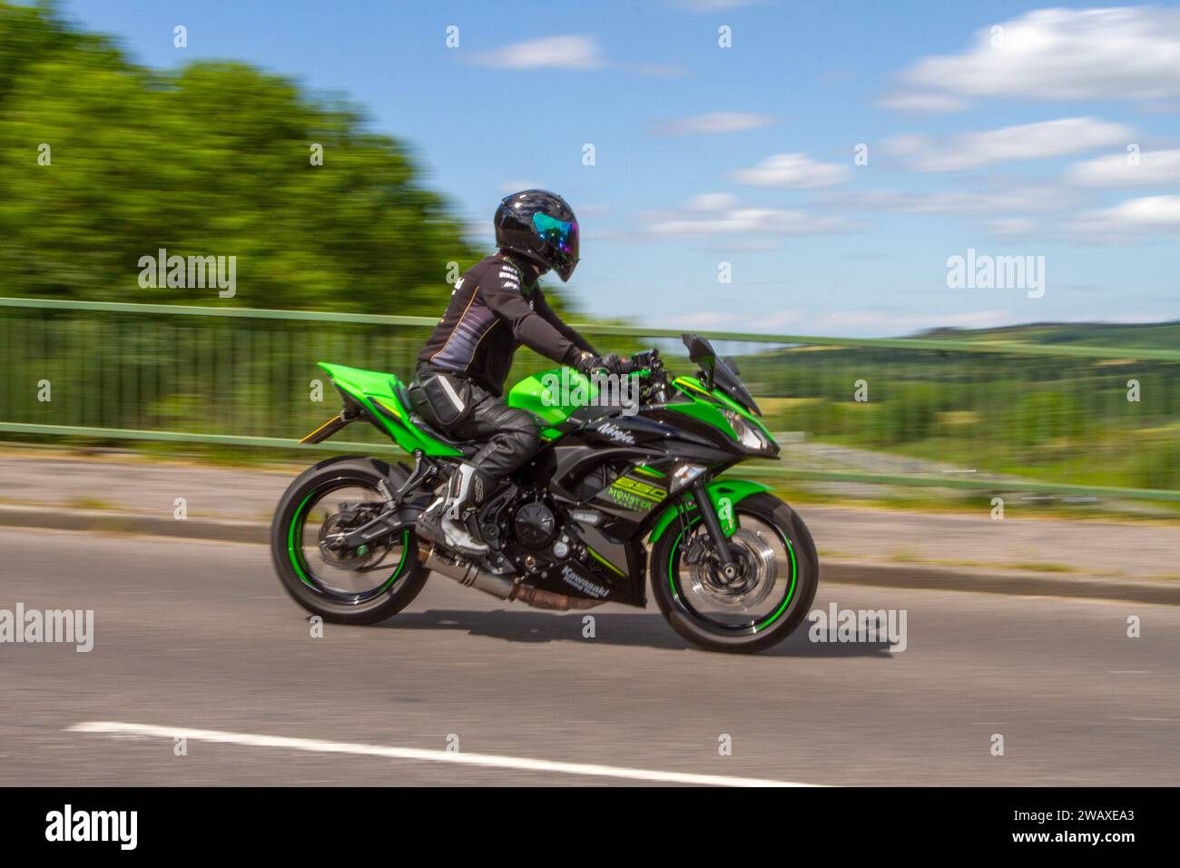 Green Kawasaki Ninja 650 Monster travelling at speed in Greater Manchester, UK Stock Photo