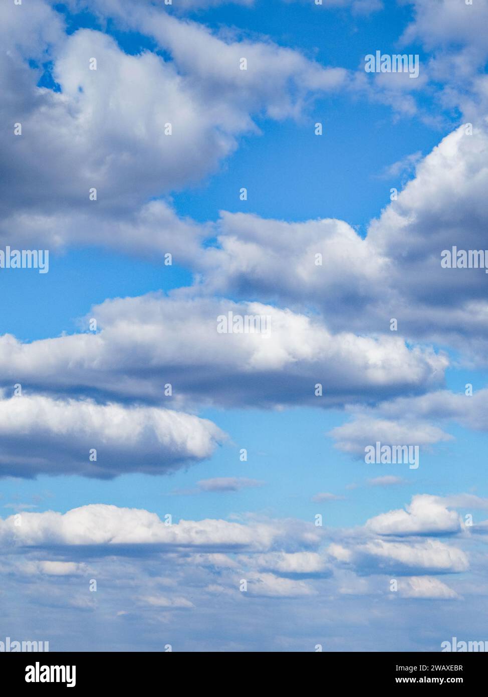 A clear sky with fluffy, white clouds scattered across the blue ...