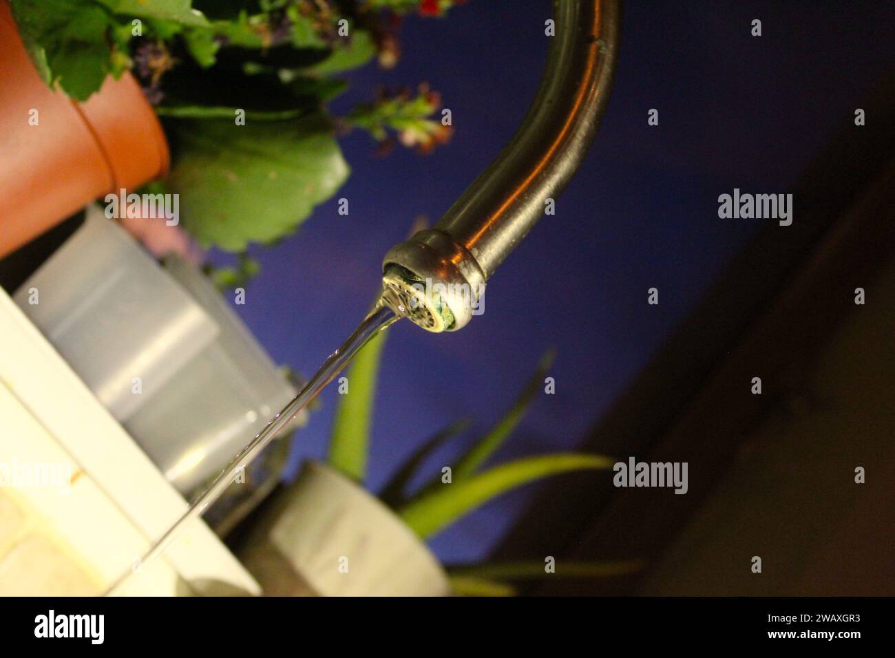 A close up photo of a silver metal sink kitchen tap dripping water into