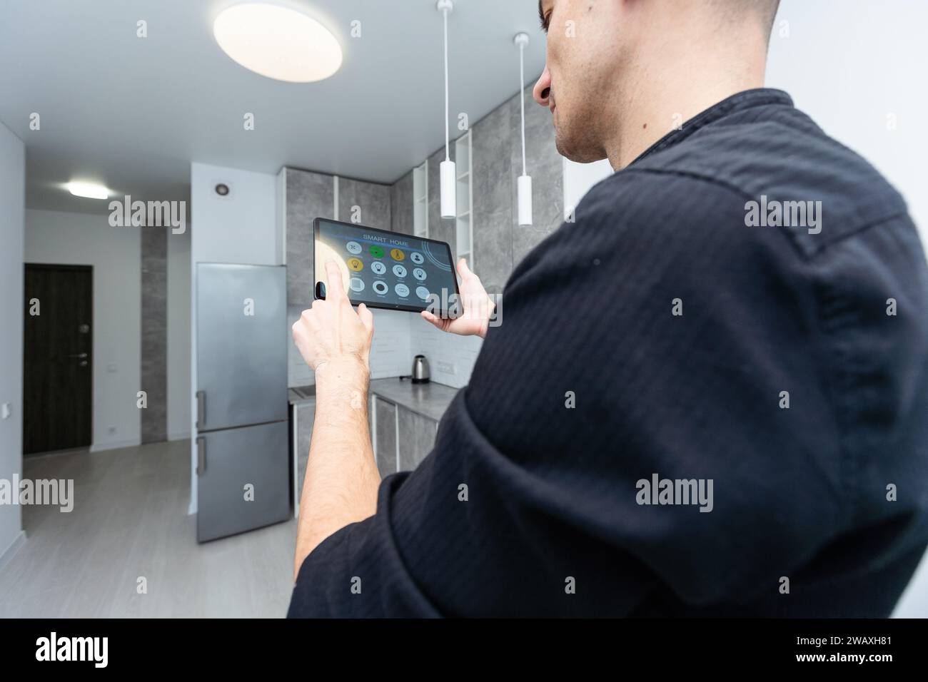 Worker with tablet computer checking alarm system indoors Stock Photo