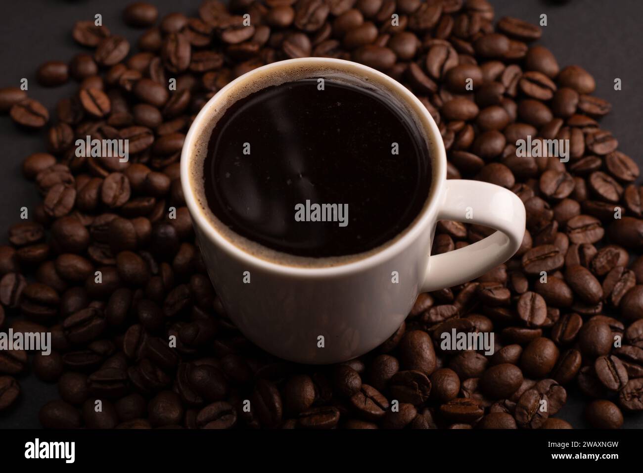 In this closeup photo, cup of espresso, by textured coffee beans