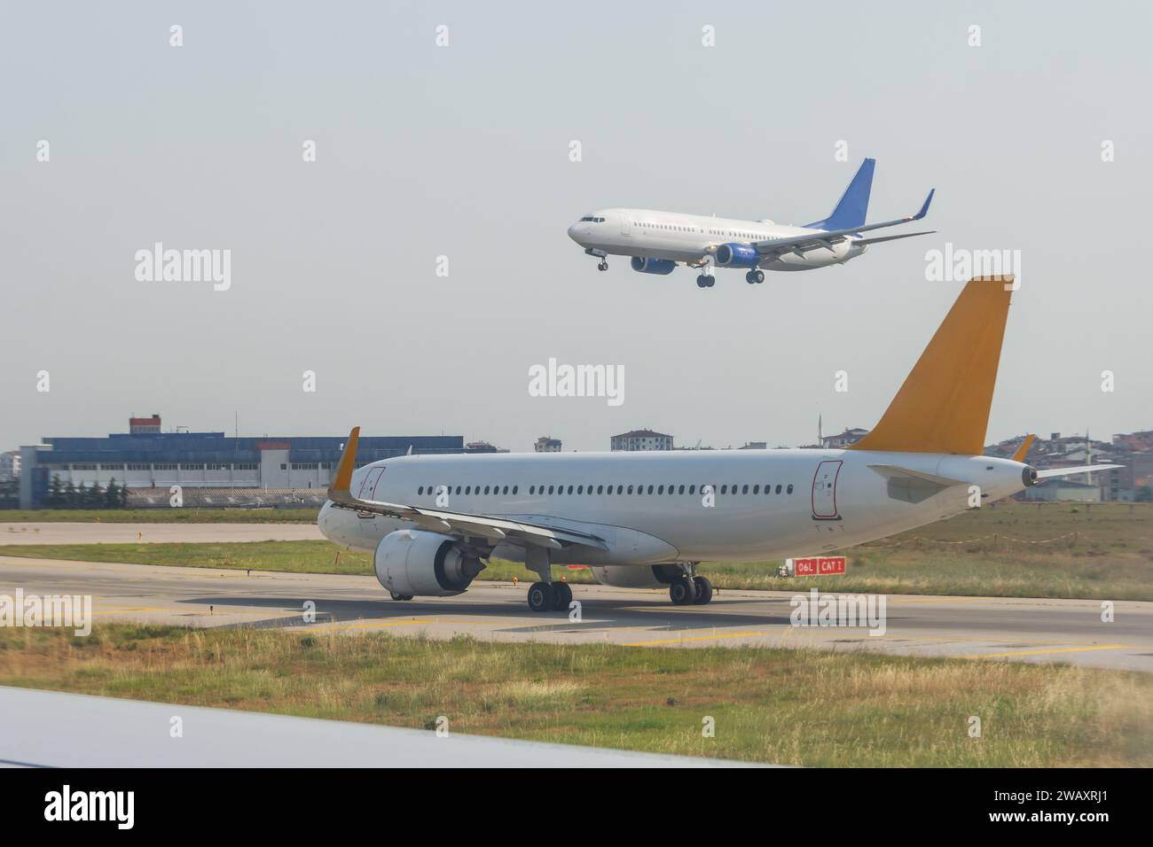 Aircraft is waiting to take off, another one lands on the runway. Airport traffic and traffic control traffic controllers. Stock Photo