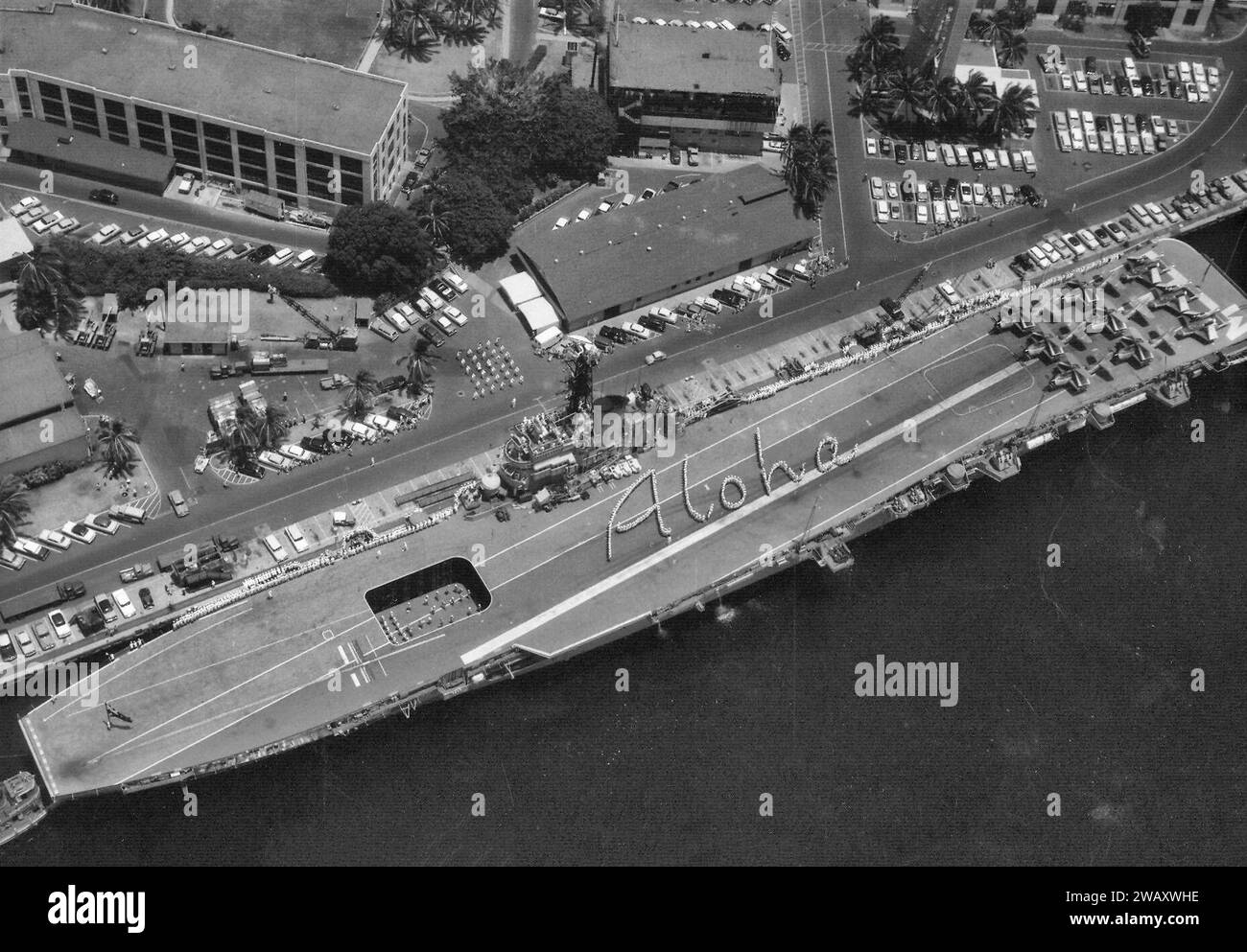 The Australian carrier HMAS Melbourne (R21) moored at Pearl Harbor, Hawaii (USA), her crew spelling out 'Aloha' on her flight deck 1958 Stock Photo