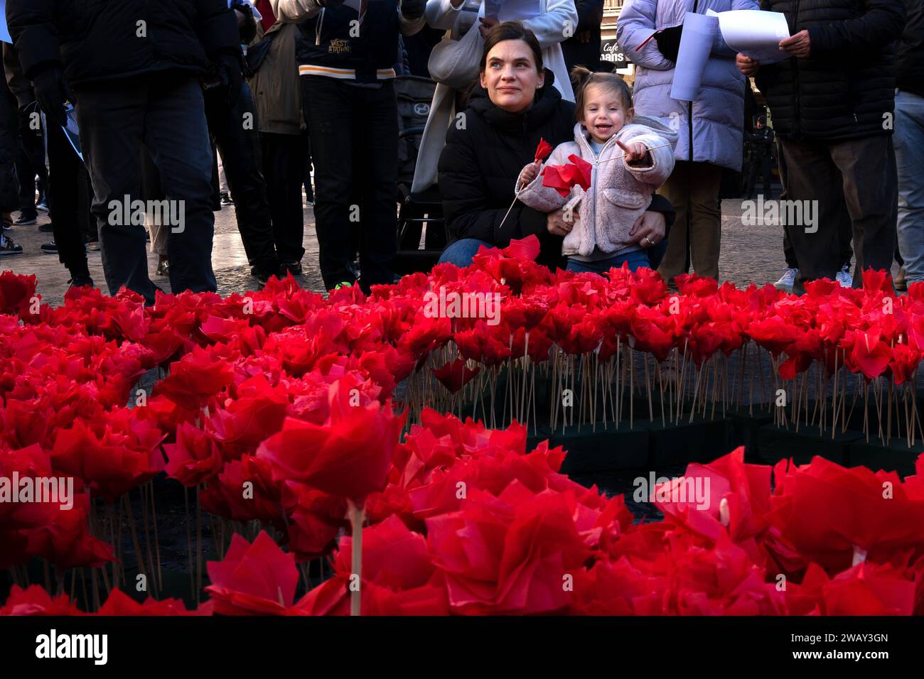 Barcelona, Spain. 07th Jan, 2024. A mother and daughter seen near the Star of David decorated with flowers during the demonstration. Around 50 people from Barcelona's Jewish community gathered in Plaça Sant Jaume to mark the third month of the kidnapping of Israeli civilians by Hamas. Credit: SOPA Images Limited/Alamy Live News Stock Photo