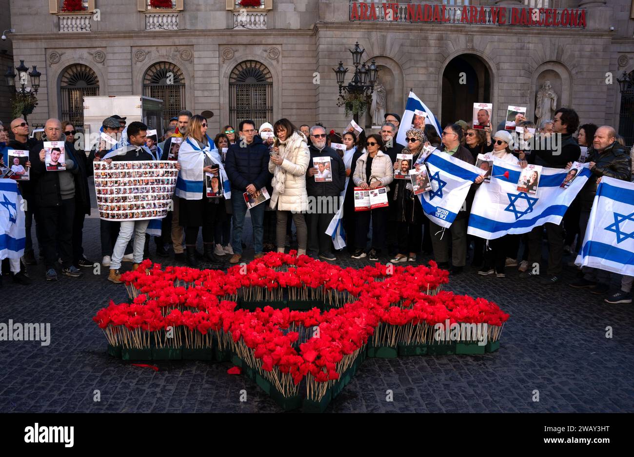 Barcelona, Spain. 07th Jan, 2024. A group of Jews stand in front of a Star of David created with red flowers to commemorate the third month of the kidnapping of Israeli civilians by the Hamas group and to pay tribute to those who have been killed during the demonstration. Around 50 people from Barcelona's Jewish community gathered in Plaça Sant Jaume to mark the third month of the kidnapping of Israeli civilians by Hamas. Credit: SOPA Images Limited/Alamy Live News Stock Photo