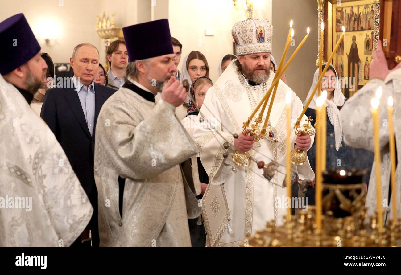 Novo-Ogaryovo, Russia. 07th Jan, 2024. Russian Orthodox Archbishop Nikolay Mosolov, right, lights candles during a Christmas mass with President Vladimir Putin at the Church of the Icon of Savior Not Made by Hands at the official presidential residence compound, January 7, 2024 in Novo-Ogaryovo, Moscow Oblast, Russia. Putin hosted families of soldiers killed in the Ukraine war for the celebration. Credit: Gavriil Grigorov/Kremlin Pool/Alamy Live News Stock Photo