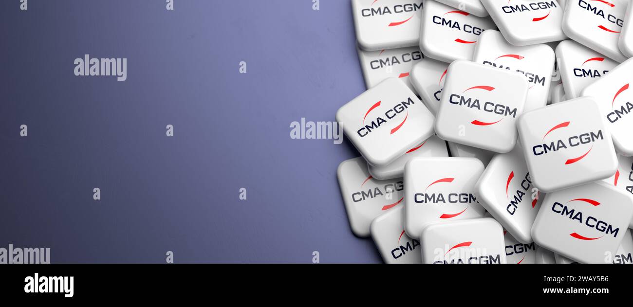 Logo of one of the five largest container shipping companies on a heap on a table: CMA CGM Group Stock Photo