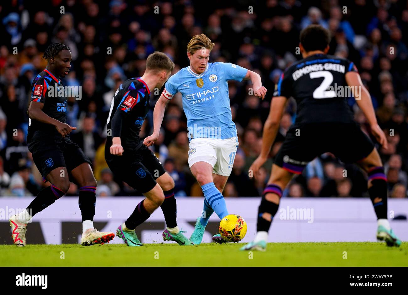 Manchester City's Kevin De Bruyne (centre) battles for the ball with Huddersfield Town's Ben Jackson (second left) during the Emirates FA Cup Third Round match at the Etihad Stadium, Manchester. Picture date: Sunday January 7, 2024. Stock Photo