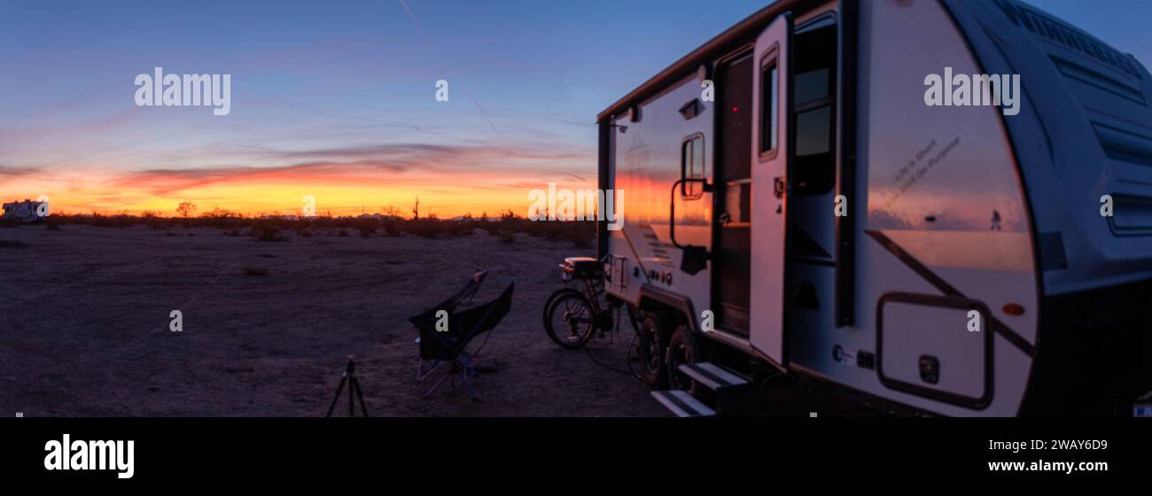 A blue truck is parked alongside a white trailer in an idyllic rural ...