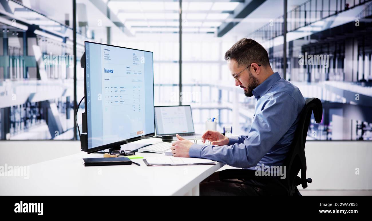 Businessperson Analyzing Invoice On Computer In Office Stock Photo