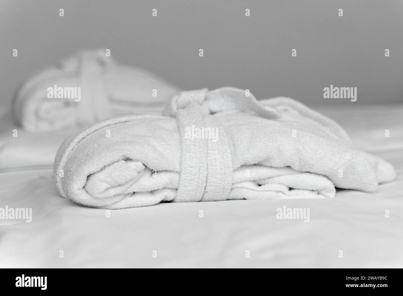 Bavaria, Germany - January 5, 2024: White bathrobe on the bed of a hotel room *** Weißer Bademantel auf dem Bett von einem Hotelzimmer Stock Photo