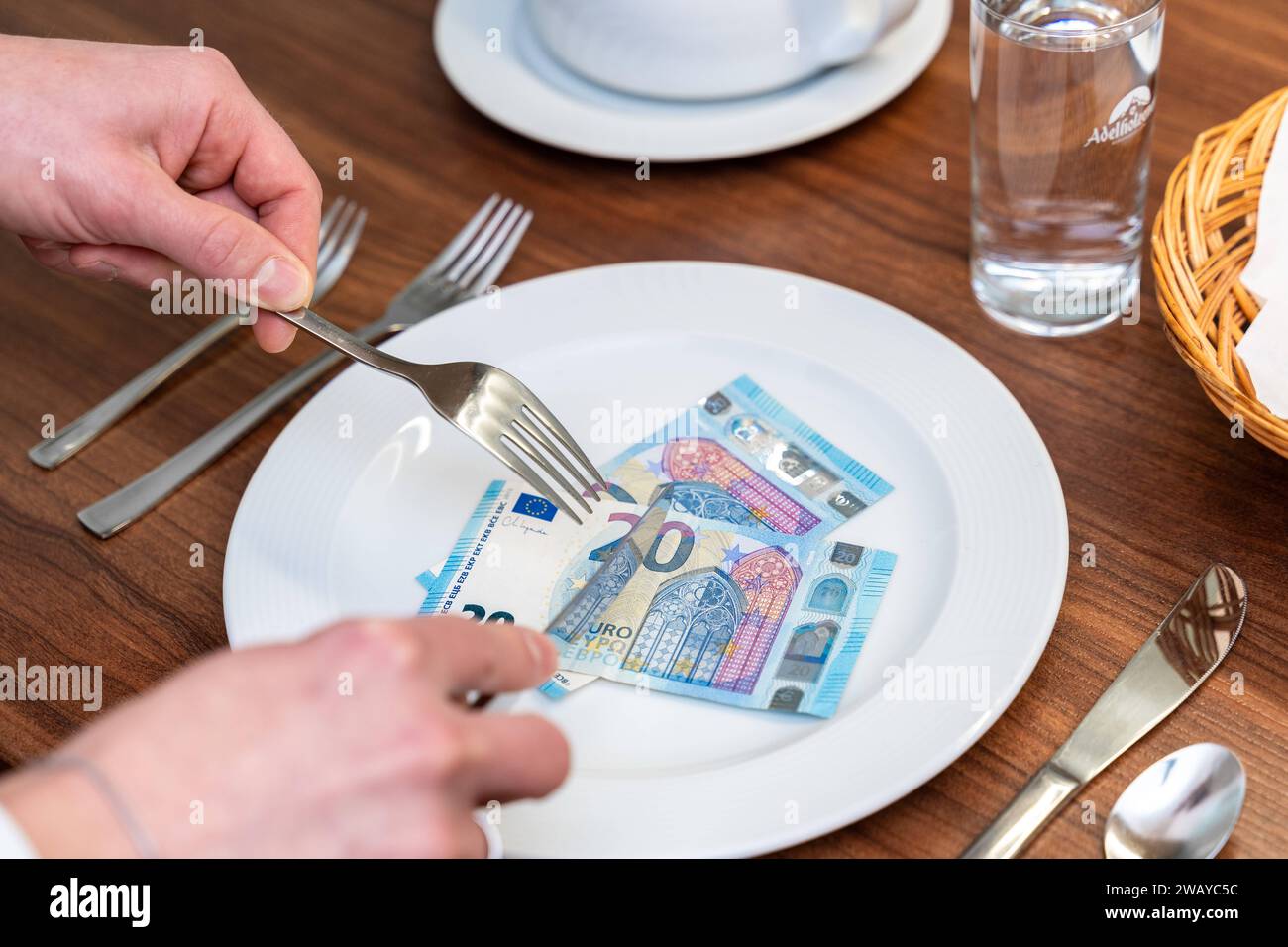 Bavaria, Germany January 6, 2024 Cost of food and gastronomy concept. Man with cutlery and