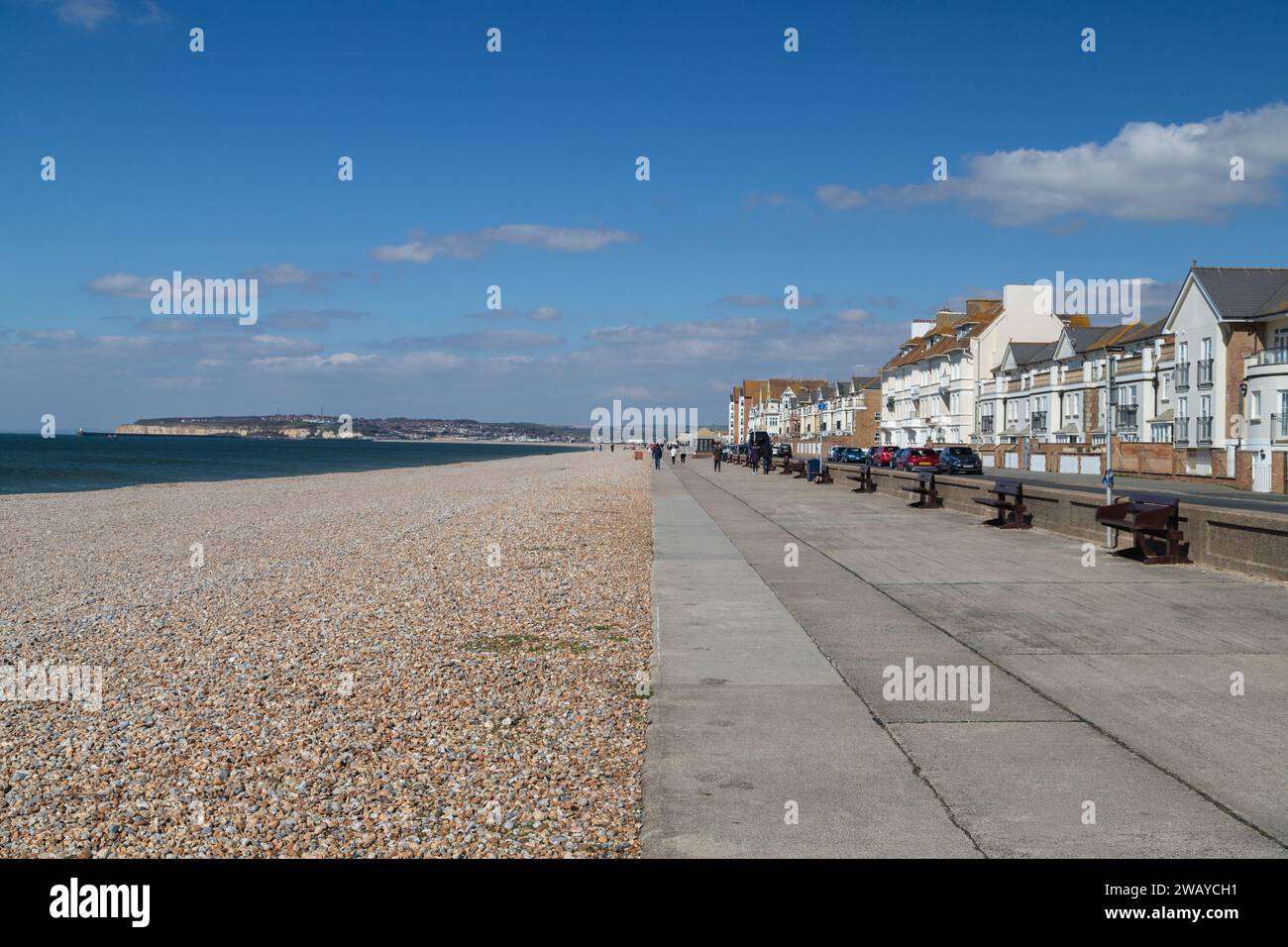 SEAFORD, UK - 3RD APRIL 23: Paths, roads and the beach in Seaford along the beachfront during the day. People can be seen on the paths Stock Photo