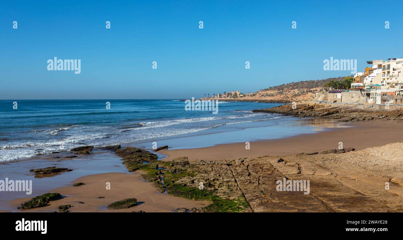 A sandy a rocky bay with beachfront houses in Taghazout, Morocco, North