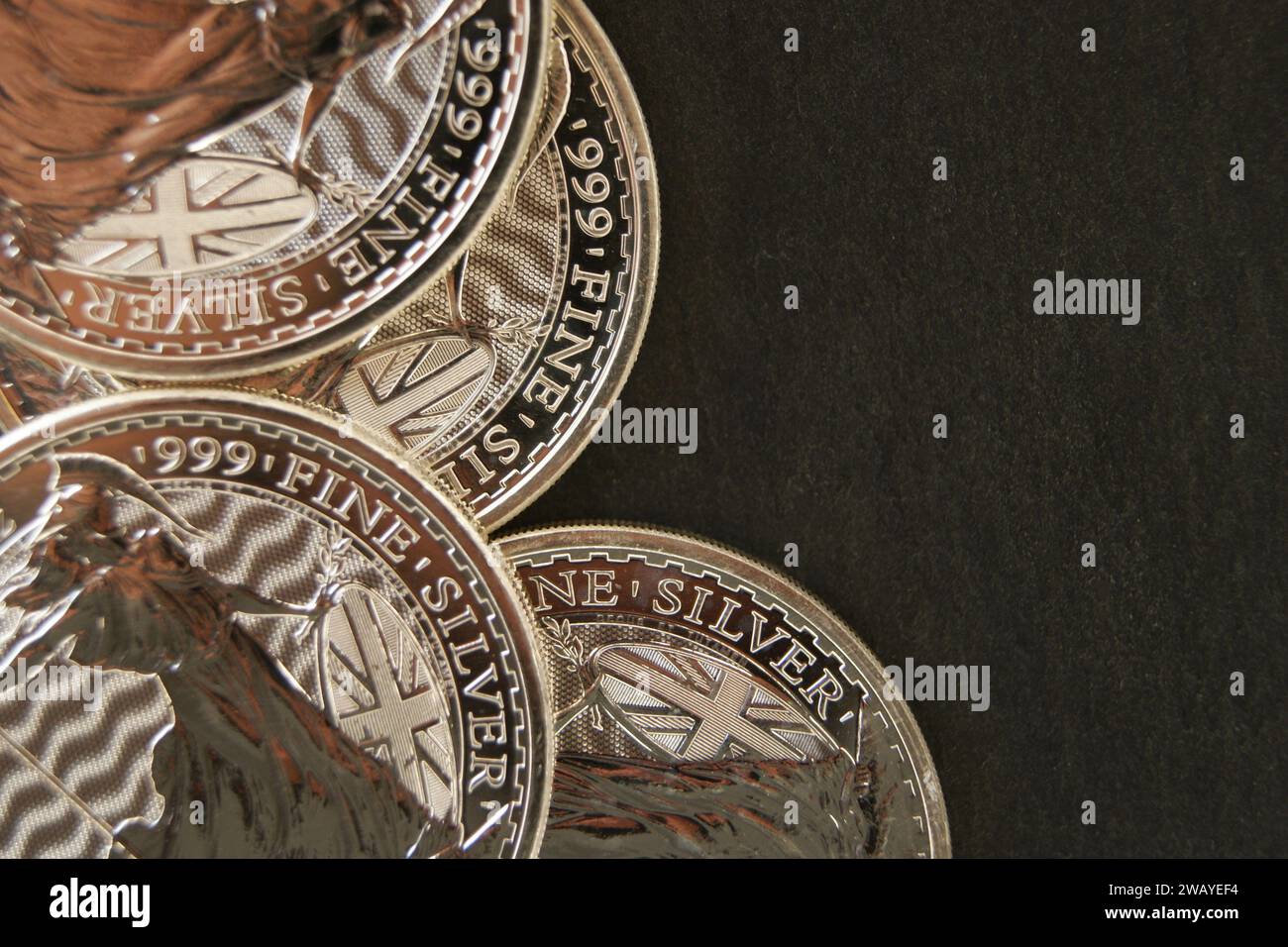 Silver coins on a dark background. Pure silver investment coins Britain. Stock Photo